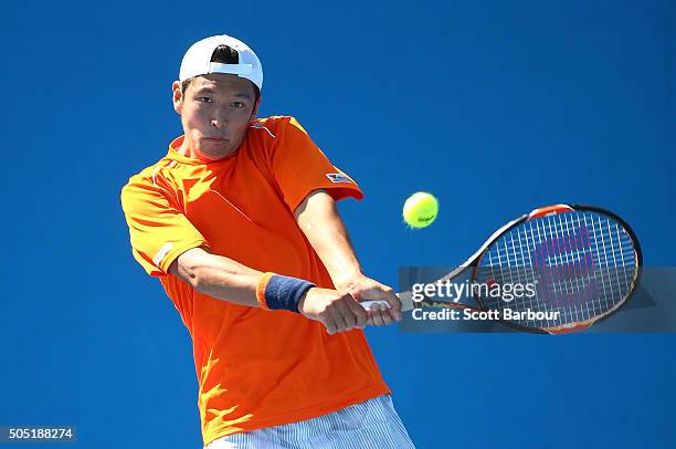 Tatsuma Ito of Japan plays a backhand in his match against Adrian Menendez-Maceiras of Spain during the third round of 2016 Australian Open...