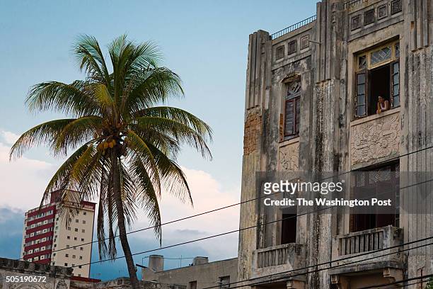 Woman leans outside of her apartment window on March 24, 2015 in the neighborhood of Verdado, two blocks from the US Interests Section. On the left...