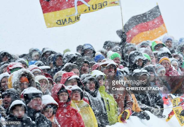 Spectators attend the ladies 12,5 kilometer mass start competition at the Biathlon World Cup during heavy snow fall on January 16, 2016 in...