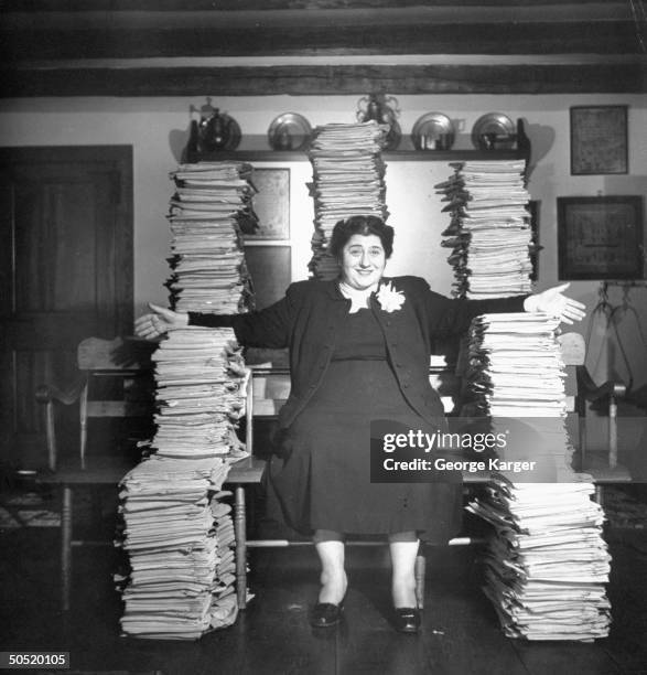 Actress & writer Gertrude Berg posing with 10 years worth of scripts for the TV program The Goldbergs.