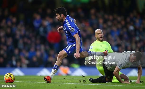 Diego Costa of Chelsea rounds Tim Howard and Phil Jagielka of Everton to score his team's first goal during the Barclays Premier League match between...