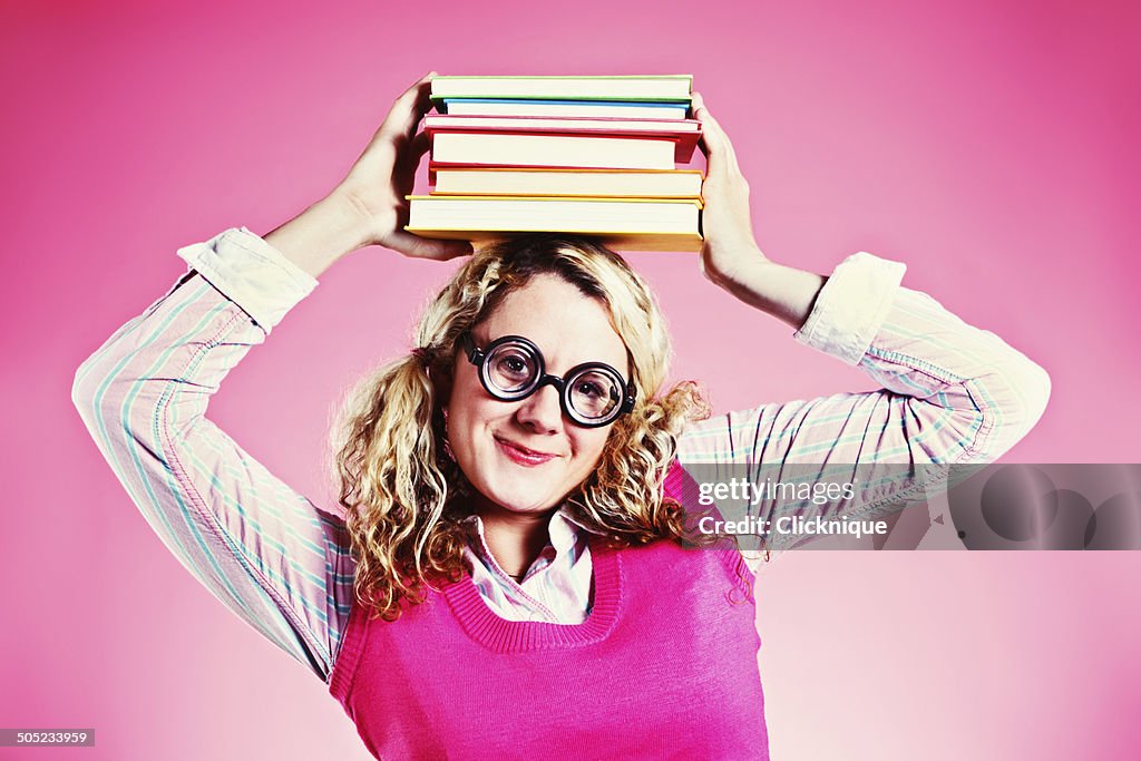 Cute but geeky student or librarian carries books on head