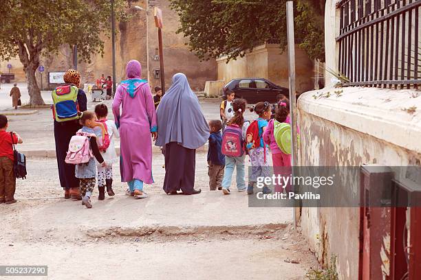 muslim women, mothers riding children from school,fez morocco, africa. - moroccan girls stock pictures, royalty-free photos & images