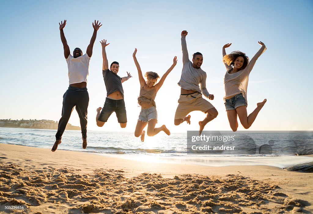 Group of friends jumping at the beach