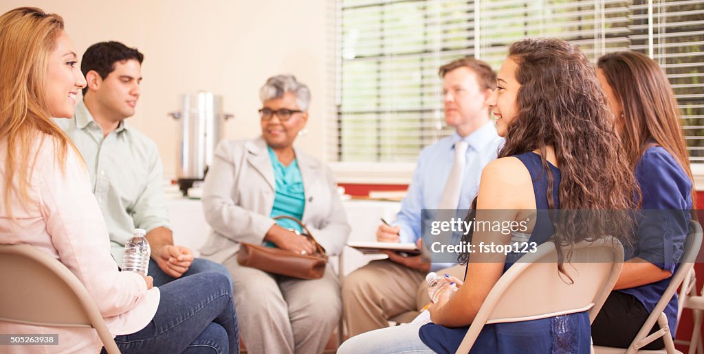 Multi-ethnic group of people in counseling session with therapist.