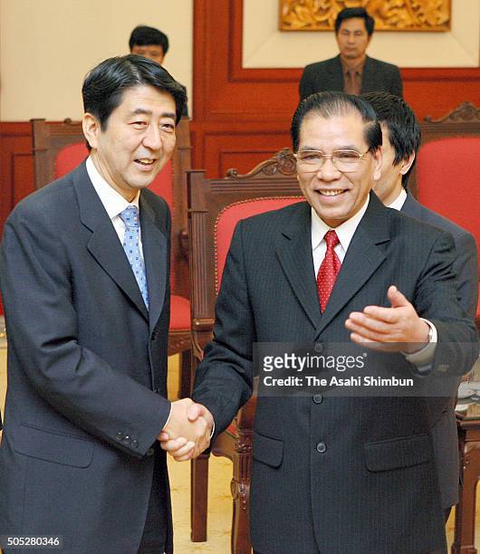 Japanese Prime Minister Shinzo Abe and Vietnam Communist Party General Secretary Nong Duc Manh shake hands prior to their meeting after the APEC...