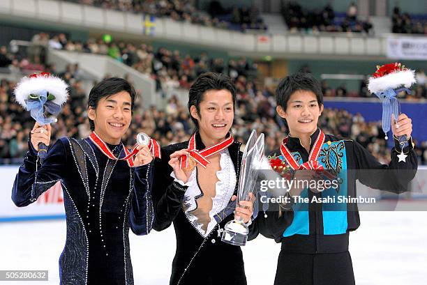 Silver medalist Nobunari Oda, gold medalist Daisuke Takahashi and bronze medalist Takahiko Kozuka pose for photographs on the podium at the medal...