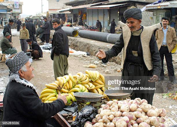 Man purchases bunch of banana at a market on December 11, 2006 in Halabja, Iraq.