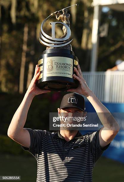 Mardy Fish holds the championship trophy after winning the Diamond Resorts Invitational at The Golden Bear Club at Keene's Point in Wintermere, Fla.,...