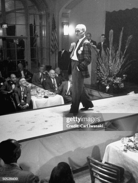 Advertising man George Bakewell sports a tartan housecoat with grosgrain collar & cuffs, during a men's fashion show for the Lions Club.