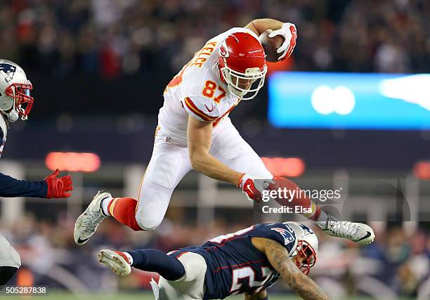 Travis Kelce of the Kansas City Chiefs jumps over Patrick Chung of the New England Patriots in the first half during the AFC Divisional Playoff Game...