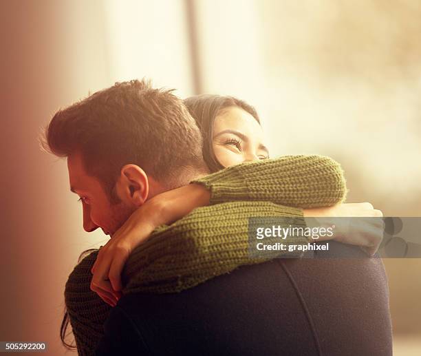 giovane coppia abbracciare una persona - stringere foto e immagini stock