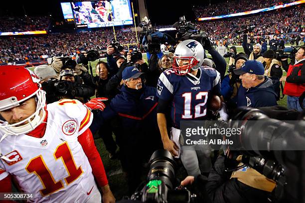 Alex Smith of the Kansas City Chiefs and Tom Brady of the New England Patriots speak while leaving the field after the AFC Divisional Playoff Game at...
