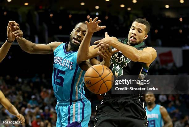 Michael Carter-Williams of the Milwaukee Bucks tries to grab a loose ball against Kemba Walker of the Charlotte Hornets during their game at Time...