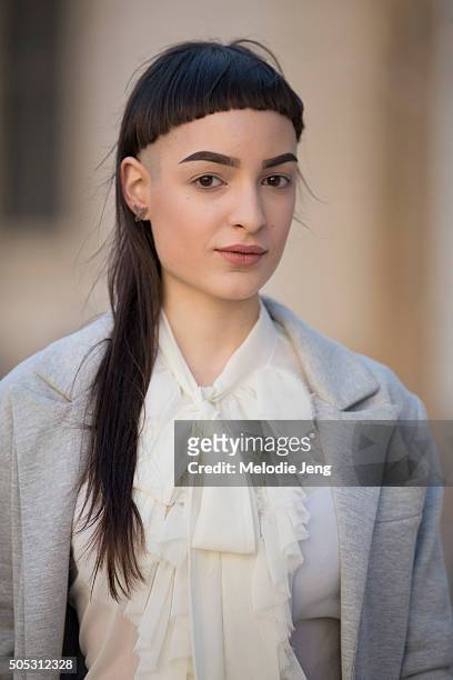 Blogger Marta Festa wears a gray Menchen thomas coat and trousers with a white ruffle-collar top and sports a bowl-cup fringe and long hair during...