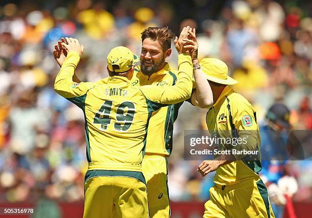 Kane Richardson of Australia is congratulated by his teammates after dismissing Rohit Sharma of India during game three of the One Day International...