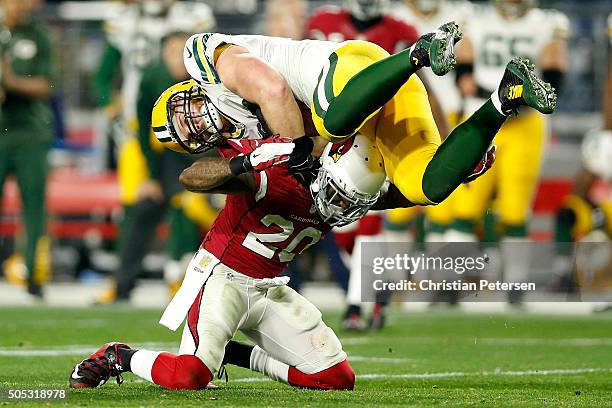 Fullback John Kuhn of the Green Bay Packers is hit by strong safety Deone Bucannon of the Arizona Cardinals during the second half of the NFC...