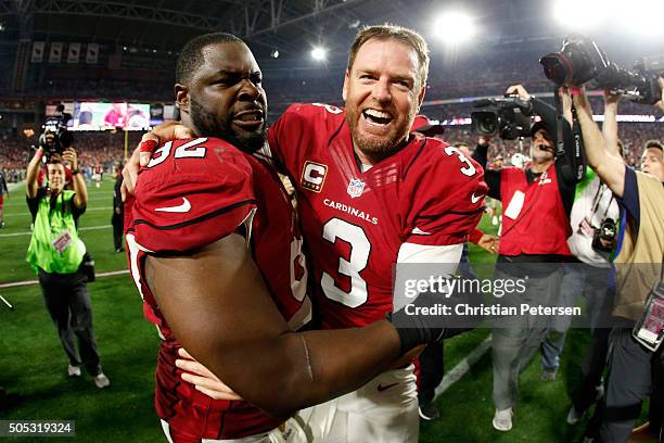 Quarterback Carson Palmer of the Arizona Cardinals celebrates with teammate defensive end Frostee Rucker after beating the Green Bay Packers 26-20 in...