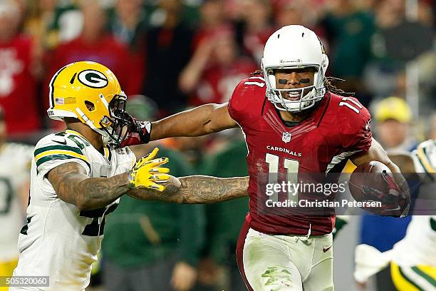 Wide receiver Larry Fitzgerald of the Arizona Cardinals stiff arms strong safety Morgan Burnett of the Green Bay Packers during overtime of the NFC...