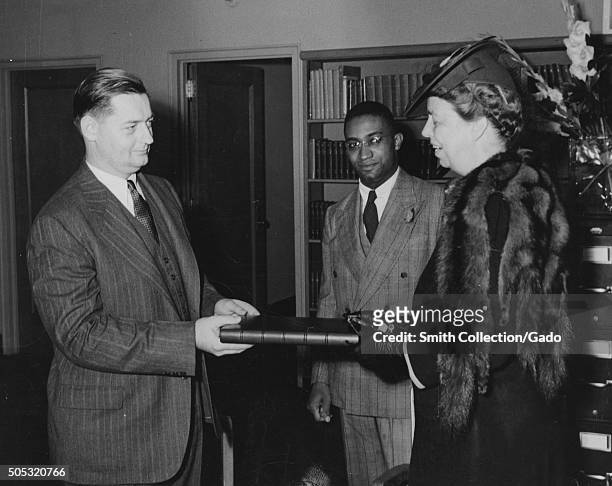 Mrs Eleanor Roosevelt presenting the President's manuscript copy of the radio address on the Atlantic Charter: Mr Francis R St John, Chief of...