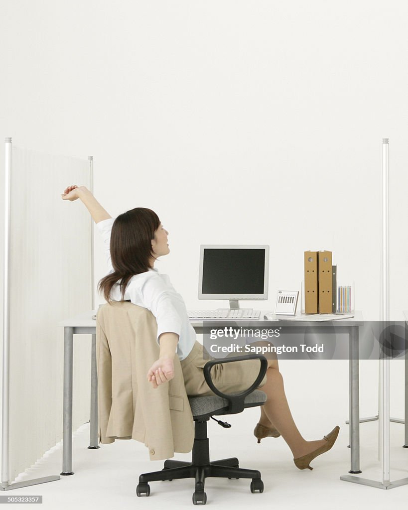 Businesswoman Stretching In Office