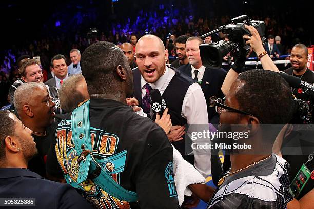 Deontay Wilder and Heavyweight Champion Tyson Fury exchange words after defeating Artur Szpilka at Barclays Center on January 16, 2016 in Brooklyn...
