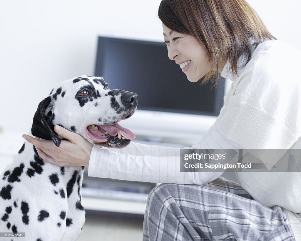 Young Woman Playing With Dalmatian