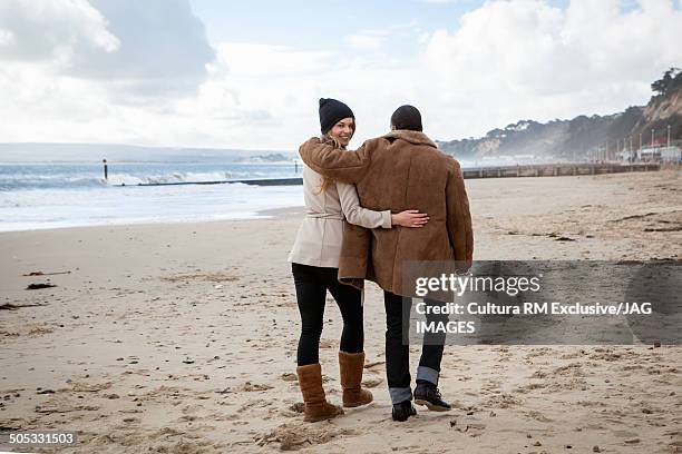 young couple strolling on beach, bournemouth, dorset, uk - romantic couple walking winter beach stock-fotos und bilder