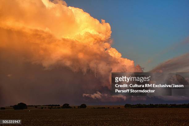 a fiery red sunset projects on the rear flank of this flanking line of supercells, pratt, kansas, usa - glow rm fotografías e imágenes de stock