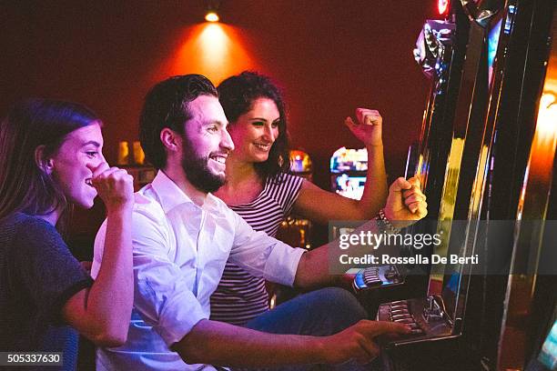 friends playing the slots - casino win stock pictures, royalty-free photos & images