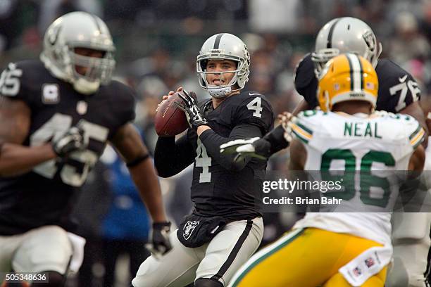 Quarterback Derek Carr of the Oakland Raiders looks for a receiver against the Green Bay Packers at the end f the first quarter on December 20, 2015...