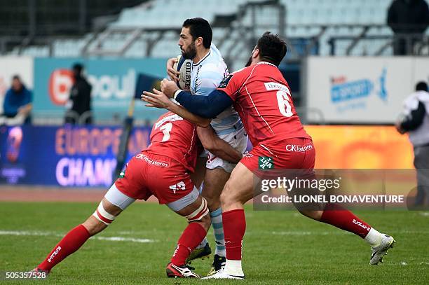 Llanelli's flankers Roy Pitman and Aaron Shingler tackle Racing Metro 92 fly-half Remi Tales during the European Rugby Champions Cup match beetween...