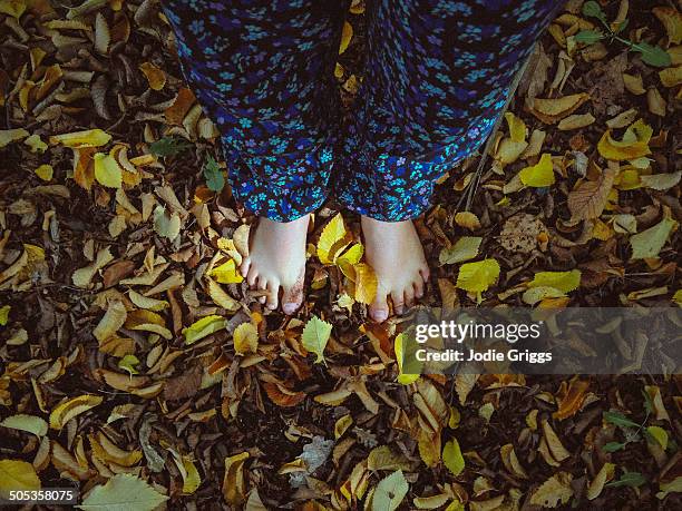 child standing barefooted in autumn leaves - floral pattern pants stock pictures, royalty-free photos & images