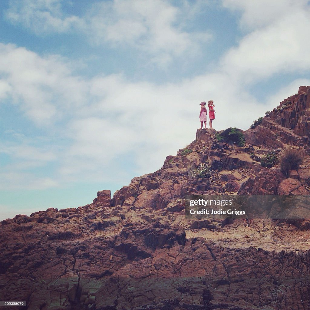 Children climbing on rocks beside the ocean