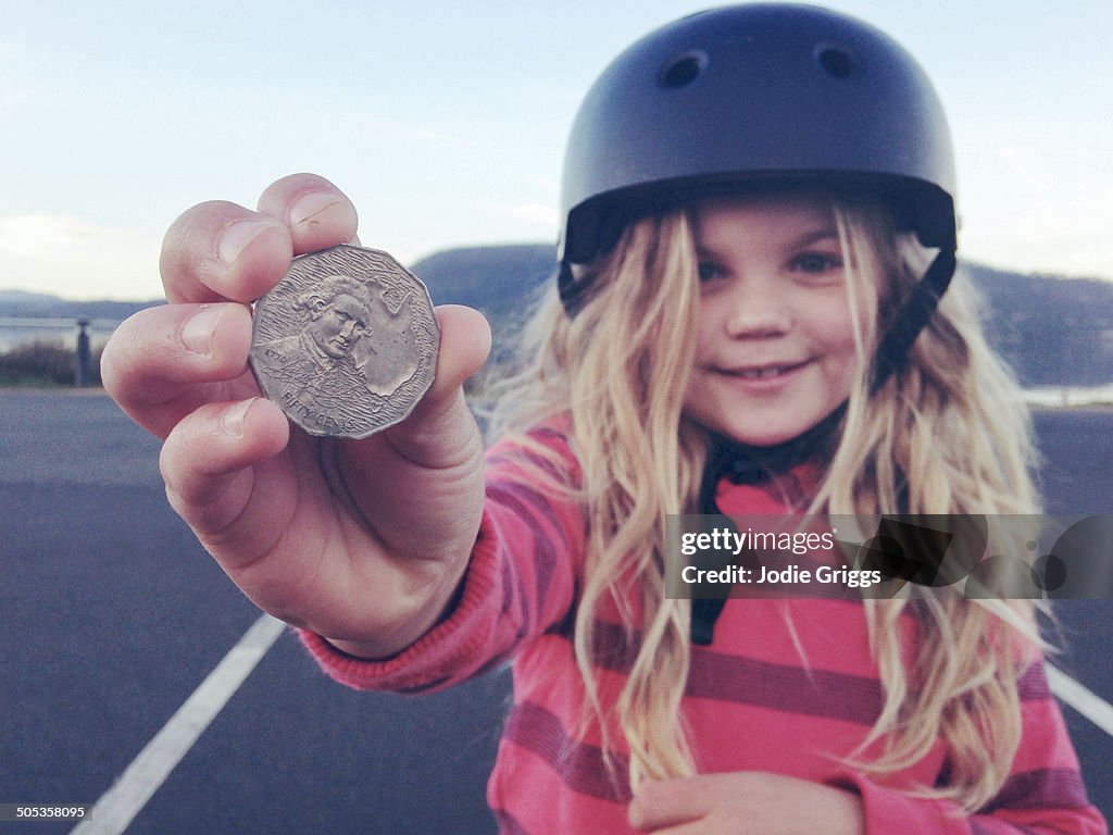 Child holding coin that she found on the ground