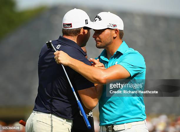 Haydn Porteous of South Africa shakes hands with Zander Lombard of South Africa as he celebrates victory on the 18th green on the East Course during...