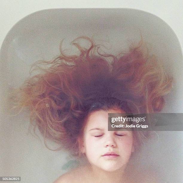 looking down on child with long hair in bathtub - bath girl stockfoto's en -beelden