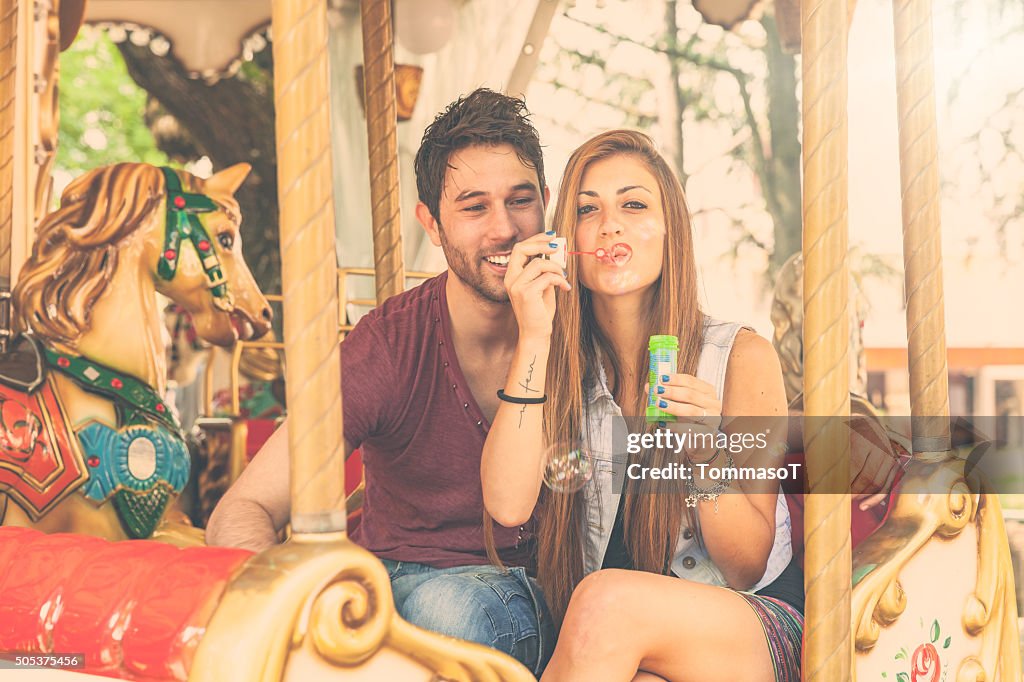 Young couple having fun on Merry-Go-Round