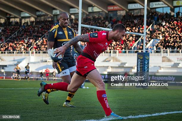 Toulon's Australian fly-half Quade Cooper scores a try despite Wasps' Fijian-Samoan wing from Sailosi Tagicakibau during the European Champions Cup...