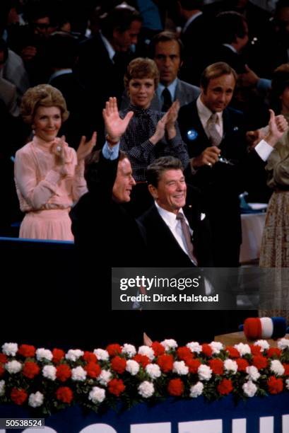 Presidential candidate Ronald Reagan and runningmate George Bush waving thumbs up as Reagan's wife Nancy, daughter Maureen and son Michael applaud...