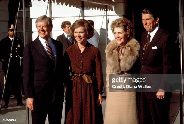 Republican President-elect Ronald Reagan and wife Nancy standing with President Jimmy Carter wife Roslyn outside the White House.