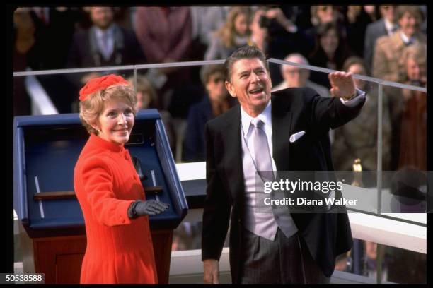 President Ronald Reagan and wife Nancy waving to crowd after swearing-in.