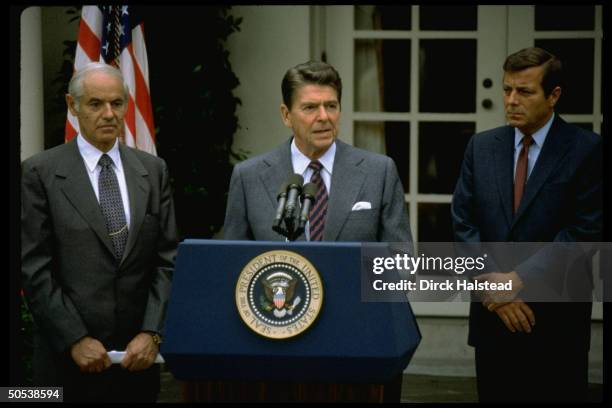 President Ronald Reagan , flanked by Andrew Lewis and William French Smith, speaking out against the unauthorized air traffic controller strike while...