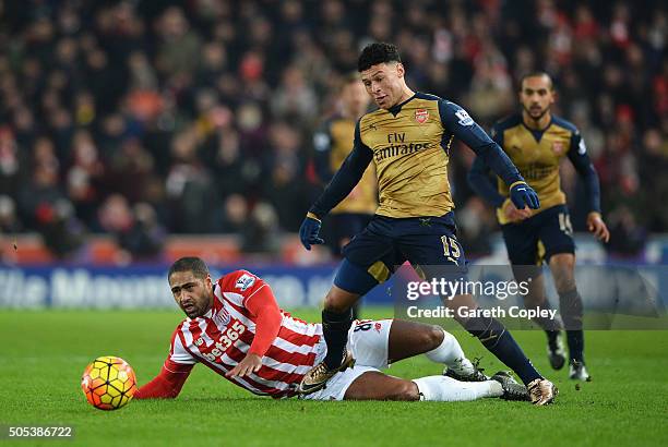 Alex Oxlade-Chamberlain of Arsenal is tackled by Glen Johnson of Stoke City during the Barclays Premier League match between Stoke City and Arsenal...