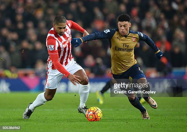 Alex Oxlade-Chamberlain of Arsenal is tackled by Glen Johnson of Stoke City during the Barclays Premier League match between Stoke City and Arsenal...