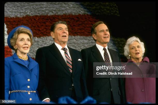 President Ronald Reagan and wife Nancy standing with Vice President George Bush and wife Barbara at post-inaugural gathering of marching bands at the...