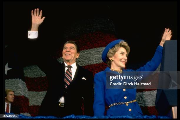 President Ronald Reagan and wife Nancy waving at post-inaugural gathering of marching bands at the Capitol Center.