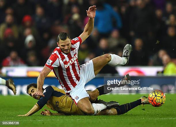 Erik Pieters of Stoke City is tackled by Mathieu Flamini of Arsenal during the Barclays Premier League match between Stoke City and Arsenal at...