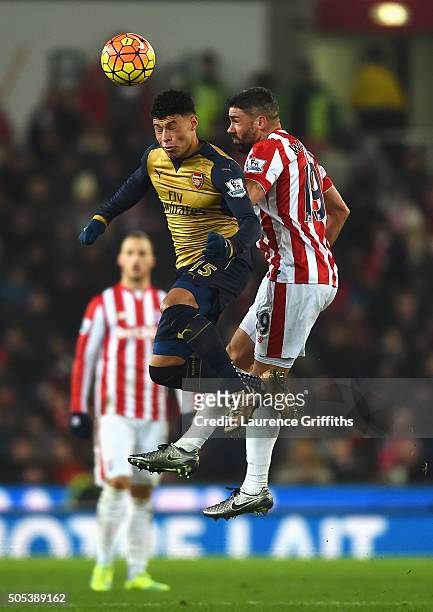 Alex Oxlade-Chamberlain of Arsenal wins a header from Jonathan Walters of Stoke City during the Barclays Premier League match between Stoke City and...