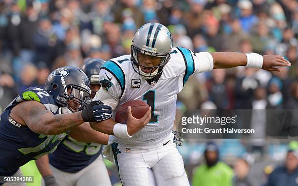 Cam Newton of the Carolina Panthers runs the ball against Michael Bennett of the Seattle Seahawks in the 2nd quarter during the NFC Divisional...